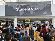 Nigerian Student Visa Guide 2025: Requirements and Steps A crowded airport terminal buzzes with students from diverse backgrounds, many aiming for a Nigerian student visa. Above them, a world map sign reads Student Visa as they carry their luggage to new academic journeys.