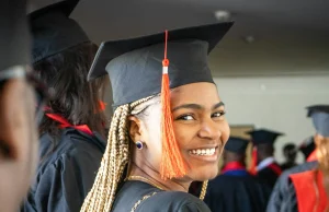 MBA Scholarships for Minorities: 15 Fully Funded Opportunities in 2026 A graduate smiling confidently in cap and gown, celebrating their academic achievement at a graduation ceremony, representing the success of minority students pursuing MBA scholarships.