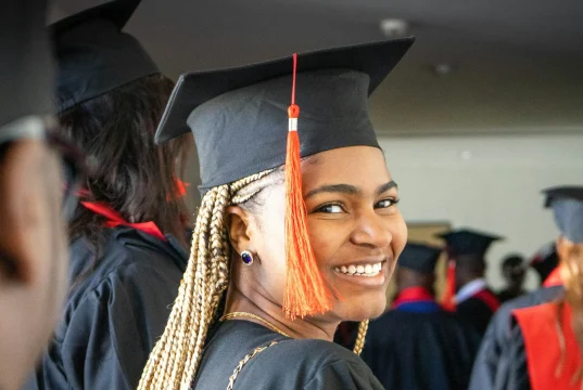 MBA Scholarships for Minorities: 15 Fully Funded Opportunities in 2026 A graduate smiling confidently in cap and gown, celebrating their academic achievement at a graduation ceremony, representing the success of minority students pursuing MBA scholarships.